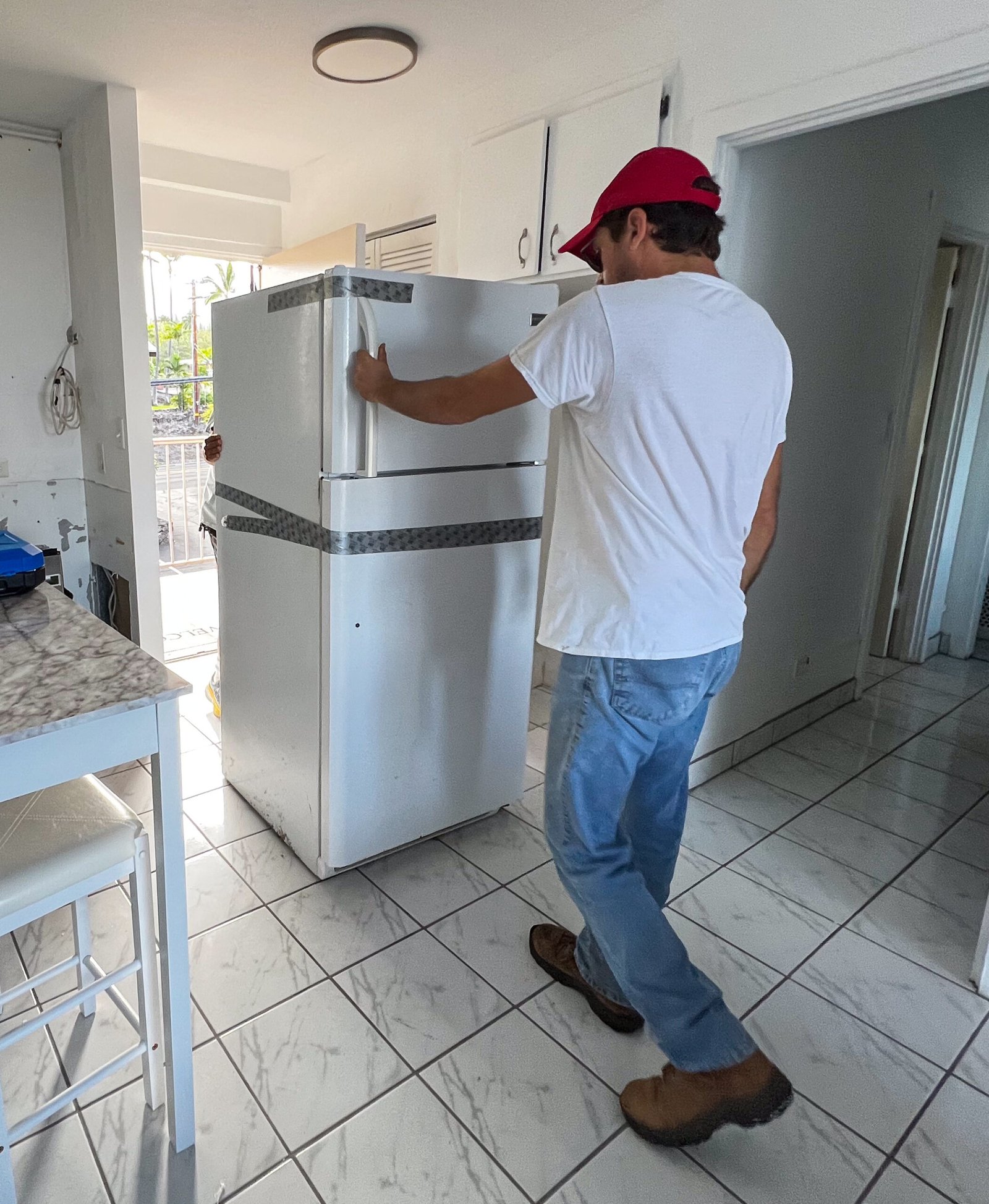 Man pushing fridge out the door