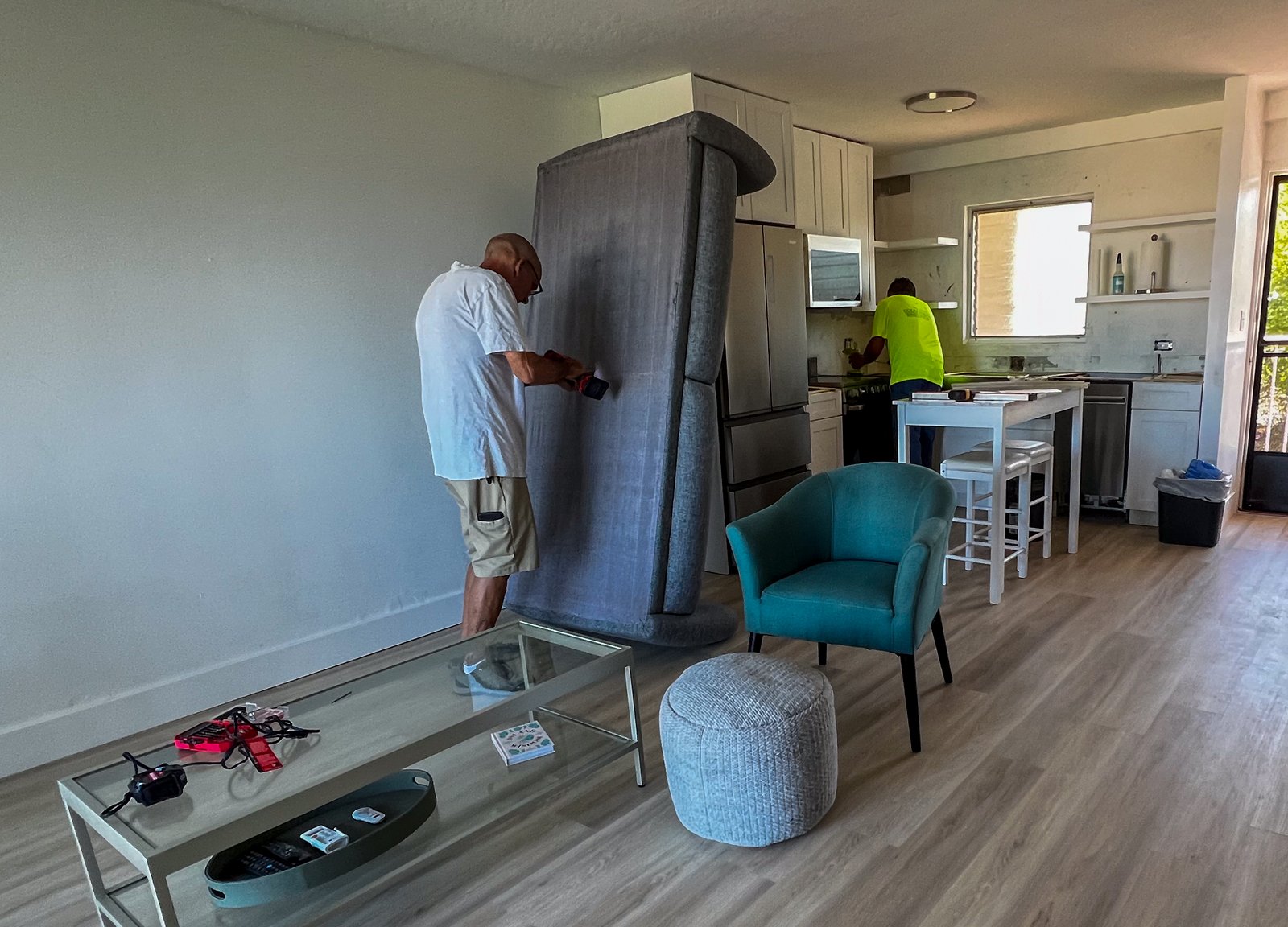 Ed putting together couch and Big Island Countertops expert measuring counters